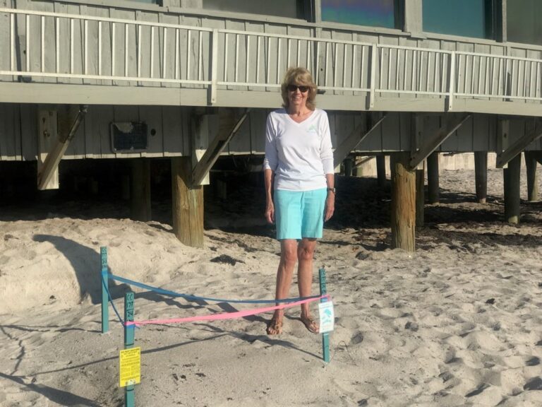 Cheryl Goff standing near her adopted Sea Turtle nest!