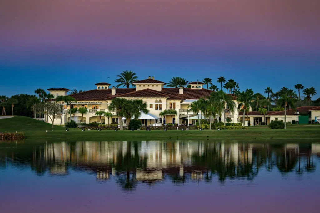 Grand Harbor Vero Beach Clubhouse at Dust as viewed from across the lake.
